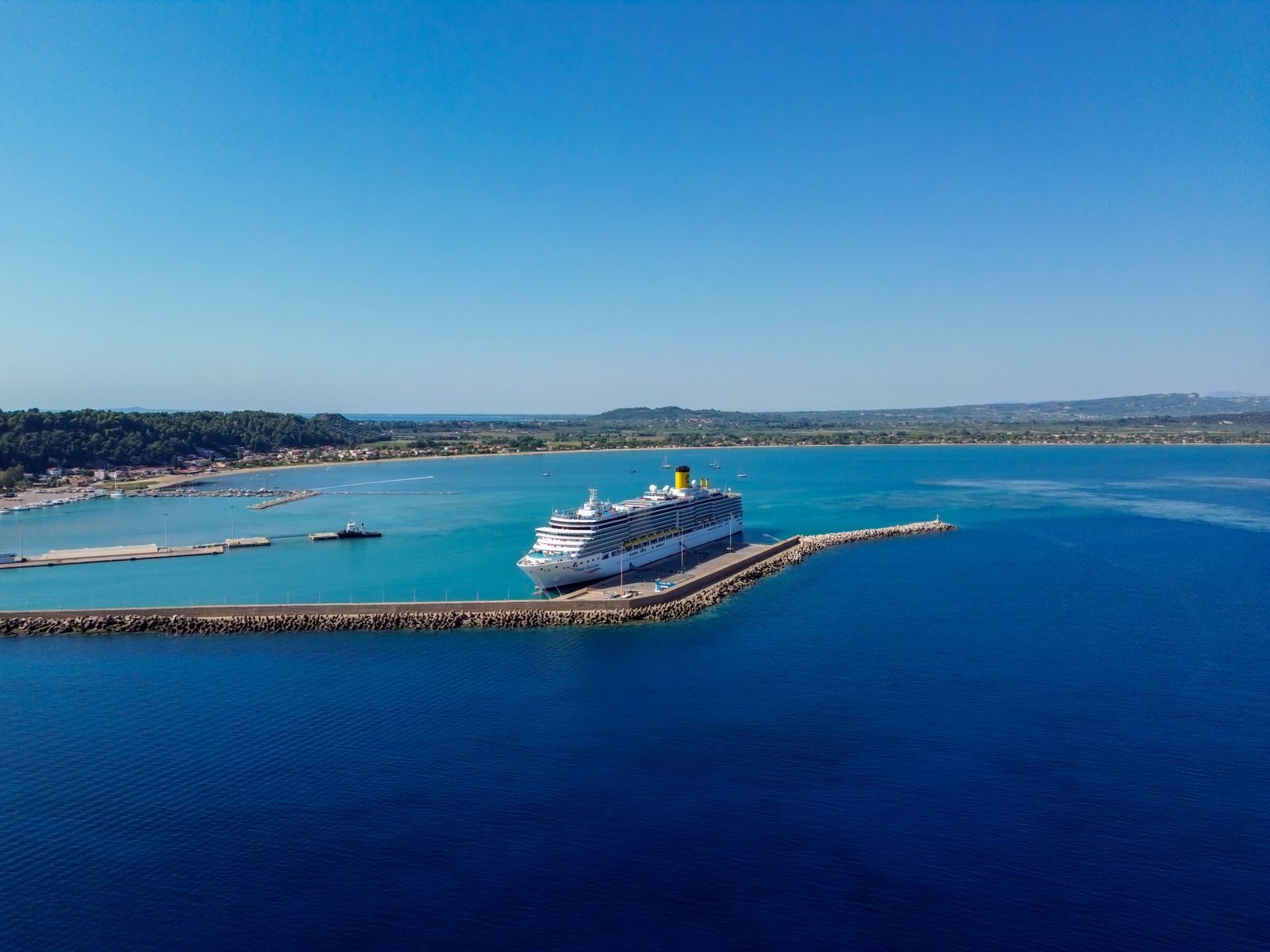 Aerial view of a cruise ship docked at a long pier in Katakolo, Greece, the sailing you map out in a cruise planning spreadsheet